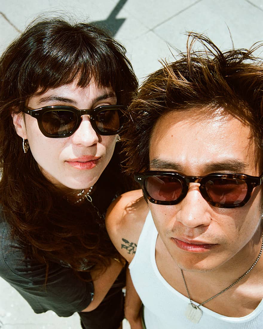 Close-up of two people in sunglasses looking up at the camera
